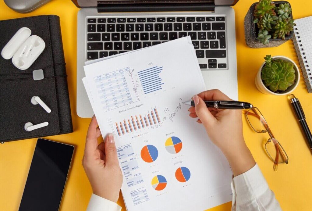Business-woman-hands-writing-on-report-top-view